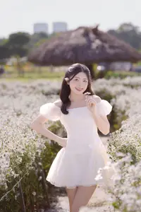 Serene Beauty: Young Woman in White Flower Field, Embracing Tranquility Under Gentle Sunlight - image 2