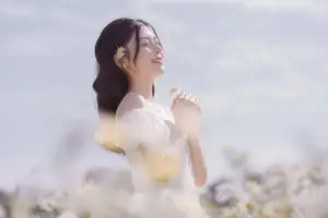 Serene Beauty: Young Woman in White Flower Field, Embracing Tranquility Under Gentle Sunlight - image 0