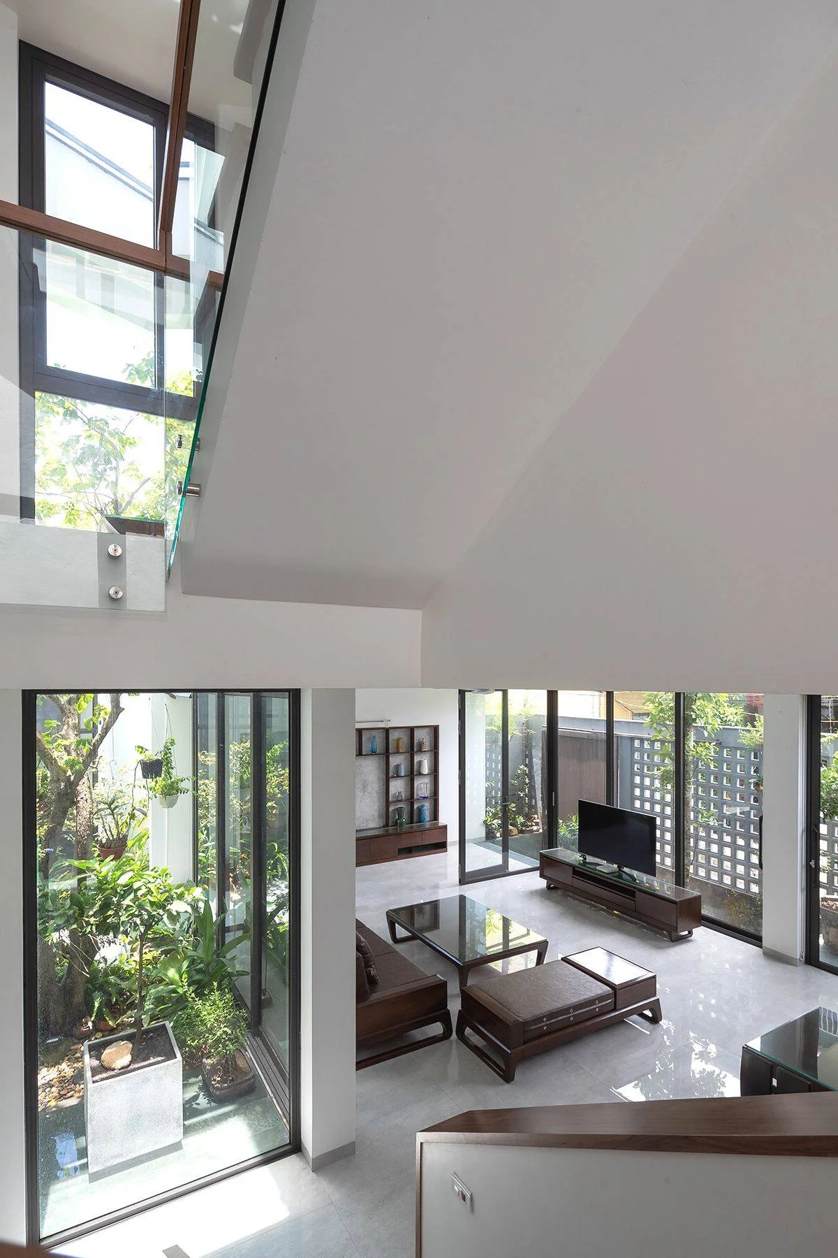Minimalist Sanctuary: Elevating Modern Living with Floor-to-Ceiling Glass Walls and Lush Indoor Greenery