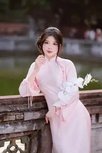 Elegant Vietnamese Beauty: Young Woman Gracefully Posing in Pink Ao Dai with White Orchids 1000026874 - image 10