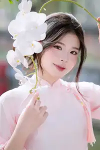 Elegant Vietnamese Beauty: Young Woman Gracefully Posing in Pink Ao Dai with White Orchids 1000026874 - image 4
