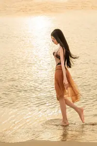 Golden Hour Serenity: Young Woman's Graceful Beach Walk - image 3