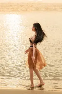 Golden Hour Serenity: Young Woman's Graceful Beach Walk - image 5