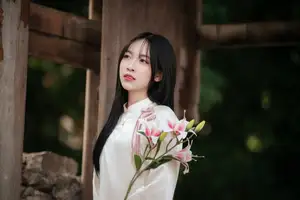 Timeless Elegance: Vietnamese Woman in Traditional Ao Dai Amidst Serene Backdrop - image 0