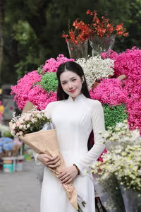 VGU No.147: Discover the enchanting grace of a Vietnamese girl in traditional Ao Dai amidst a vibrant flower market - image 0
