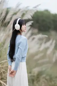 Explore Serene Beauty: Long-Haired Girl Immersed in Music Amidst Pampas Grass - image 1