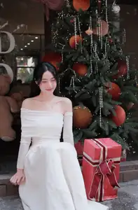 Elegant Girl in Off-Shoulder White Dress Welcoming Christmas, Showcasing Gentle Beauty and Holiday Season Style. 1000027390 - image 5