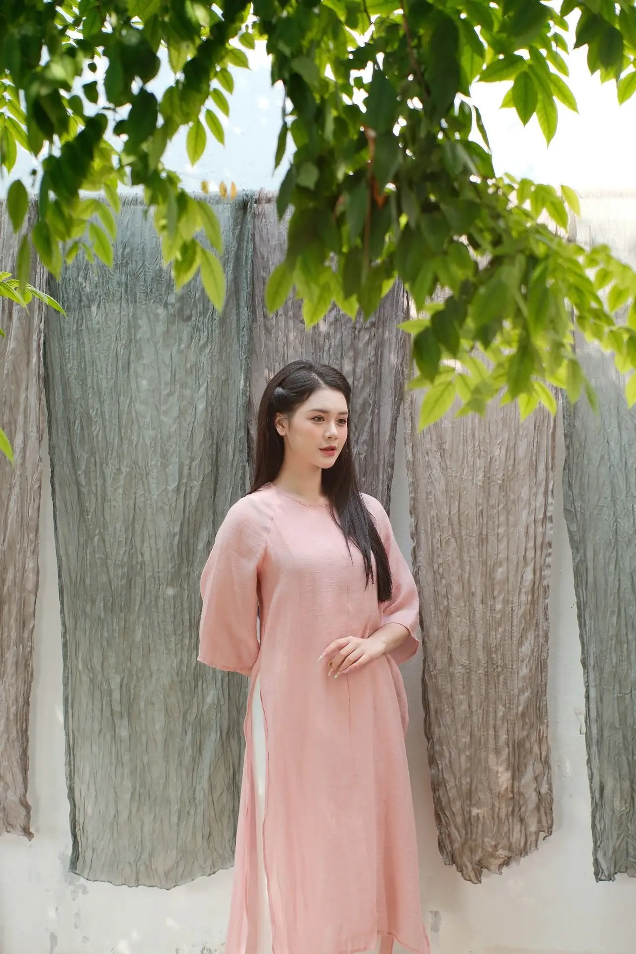 Discover Serene Vietnamese Beauty: Elegant Woman in Pink Linen Dress Amidst Floral Charm