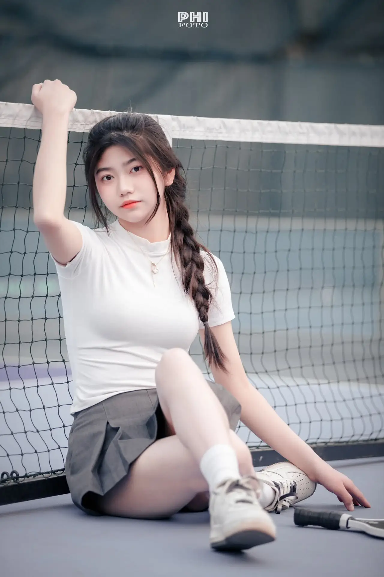 Pensive Break on Court: Young Tennis Player Recharges Energy After Intense Training Session