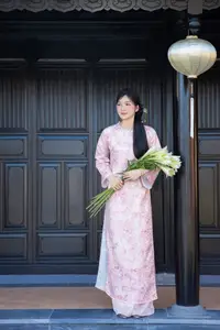 Graceful Asian Lady in Pink Ao Dai with Pristine White Lilies in Traditional Setting - image 0
