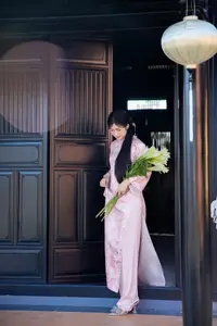 Graceful Asian Lady in Pink Ao Dai with Pristine White Lilies in Traditional Setting - image 9